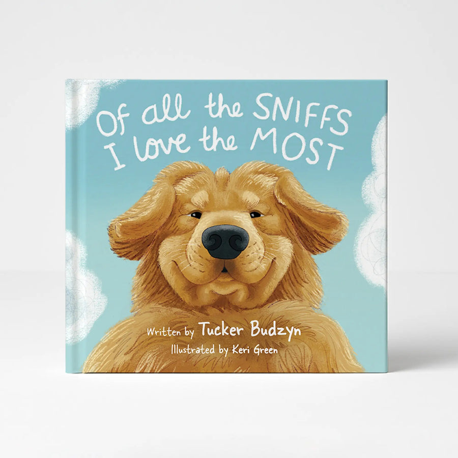 The front cover of the children's book 'Of all the SNIFFS I love the MOST' by Tucker Budzyn, illustrated by Keri Green. The cover features a golden retriever dog on a light blue background with white clouds and white handwritten text.